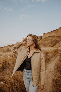 Woman standing on field against sky