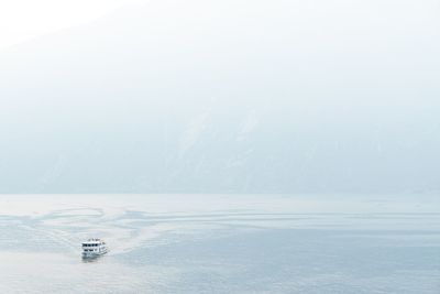 Ferry boat sailing in sea against sky during foggy weather