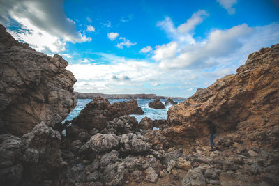 Rock formations by sea against sky