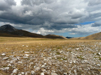 Scenic view of land and mountains against sky