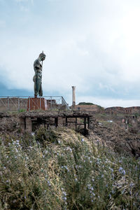 Statue by sea against sky