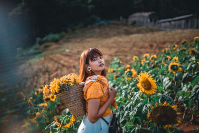Full length of woman standing on sunflower field