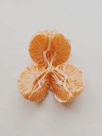 Close-up of orange slice over white background