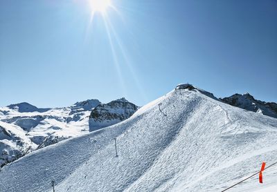 Scenic view of snowcapped mountains against sky on sunny day