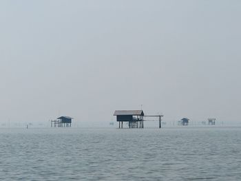 View of stilt structures in calm sea
