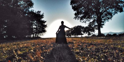 Rear view of woman standing on field