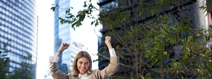 Low angle view of woman standing against trees