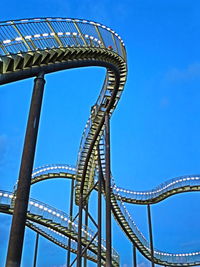 Low angle view of metal structure against blue sky