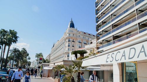 People on street against buildings in city