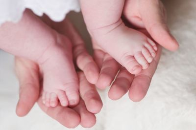 Cropped hands holding baby feet