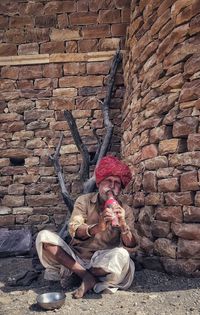 Picturesque view of an old man playing a traditional flute in front of the jaisalmer fort