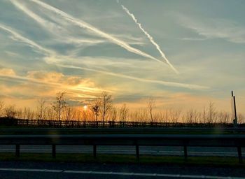 Scenic view of vapor trails against sky during sunset