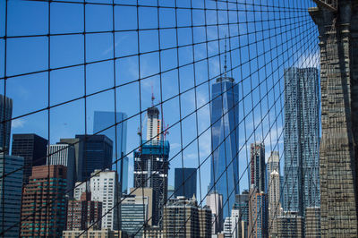 Low angle view of skyscrapers against blue sky