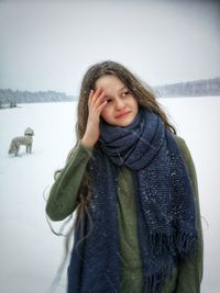 Portrait of smiling woman standing in snow
