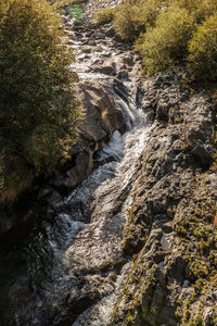 High angle view of stream flowing through rocks
