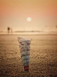 Close-up of sand on beach against sky during sunset
