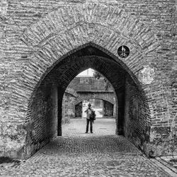 Rear view of woman walking in tunnel