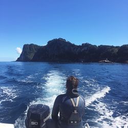 Rear view of woman looking at sea against clear sky