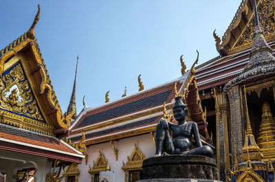 Low angle view of statue against temple building