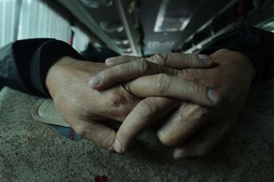 Cropped hands of man on seat in bus