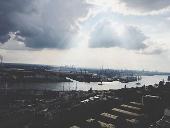 Aerial view of city by sea against sky