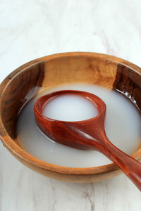 Makgeolli, traditional korean alcoholic rice wine drink, served on wooden bowl with spoon, 