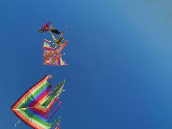 Low angle view of kite against clear blue sky