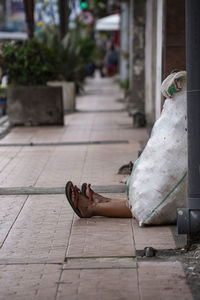 Woman relaxing on sidewalk in city