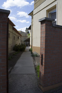 Empty road amidst buildings against sky