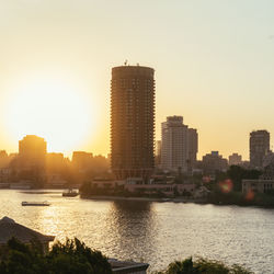 River by city against clear sky during sunset