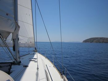 Sailboat sailing on sea against clear sky