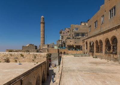 Buildings in city against clear blue sky