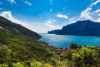 Scenic view of sea and mountains against blue sky