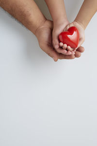 Low section of woman holding hands over white background