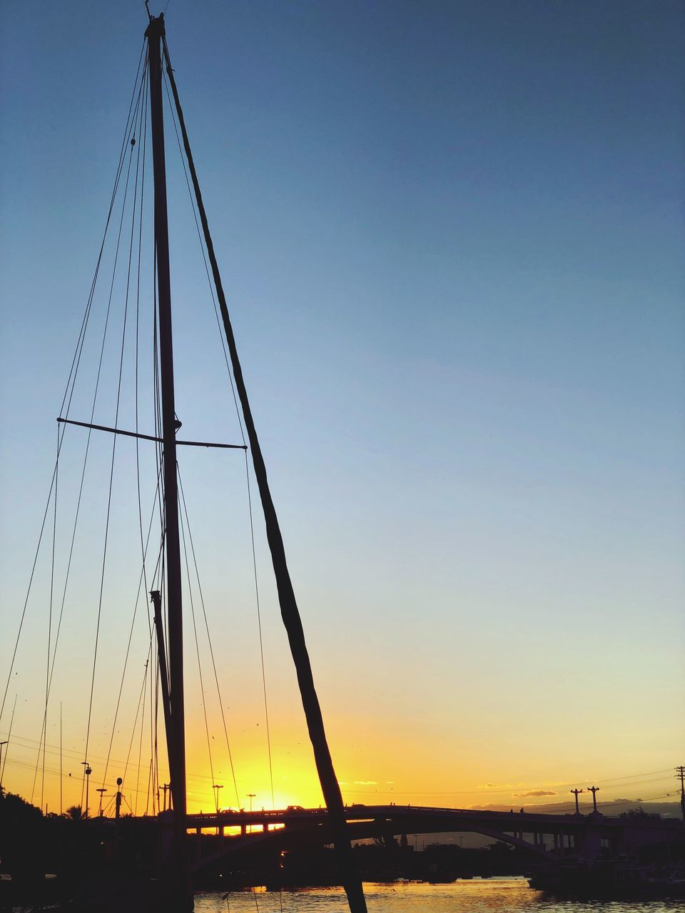 sky, sunset, transportation, mode of transportation, no people, nature, sailboat, nautical vessel, silhouette, water, architecture, mast, bridge - man made structure, bridge, built structure, orange color, pole, beauty in nature, outdoors, clear sky