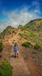 High angle view of woman hiking on mountain trail