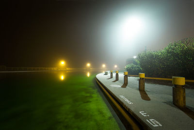 Illuminated street lights against clear sky at night