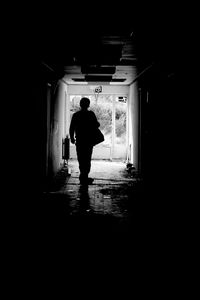 Rear view of silhouette man walking in building