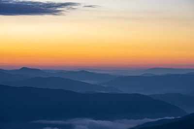 Scenic view of silhouette mountains against sky during sunset