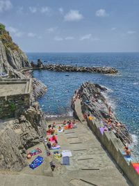 High angle view of rocks by sea against sky