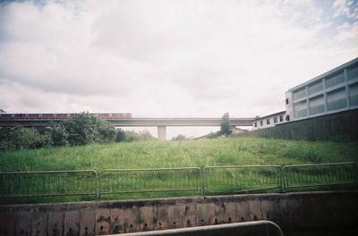 View of green landscape against cloudy sky