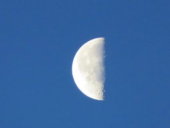 Low angle view of moon against blue sky