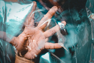 Palm of hand seen through transparent plastic