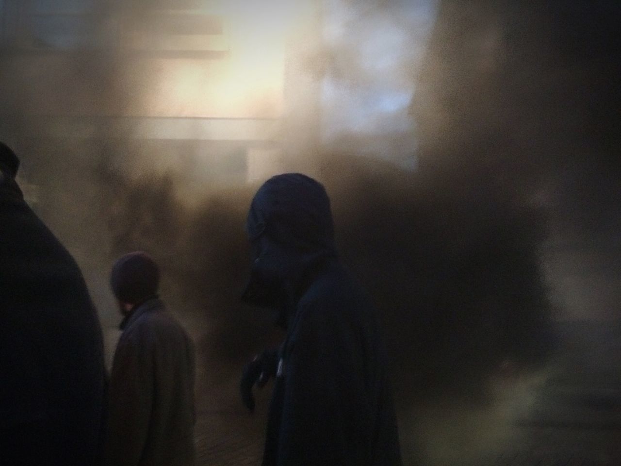 REAR VIEW OF MAN AND WOMAN WALKING IN CORRIDOR