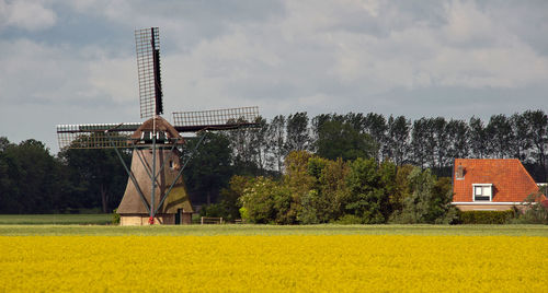 Traditional windmill on field against sky