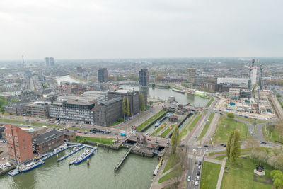 High angle view of river amidst buildings in city against sky