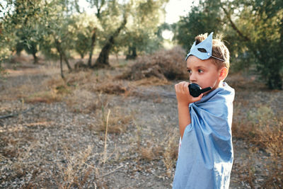 Child disguised as a blue superhero takes the walkie talkie to ask for