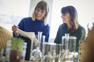 Smiling owners discussing over papers at boutique