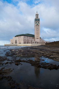 Historical mosque by sea against sky