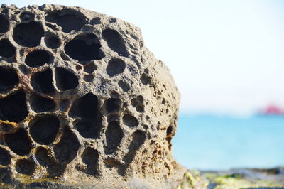 Close-up of rocks on shore against sky